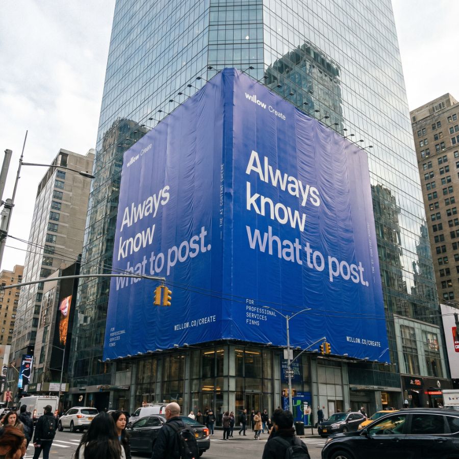 Willow Create building wrap on a glass skyscraper reading 'Always know what to post.'