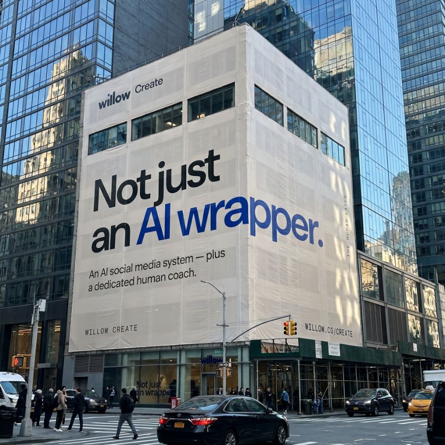 Willow Create building wrap reading 'Not just an AI wrapper — an AI social media system plus a dedicated human coach.'